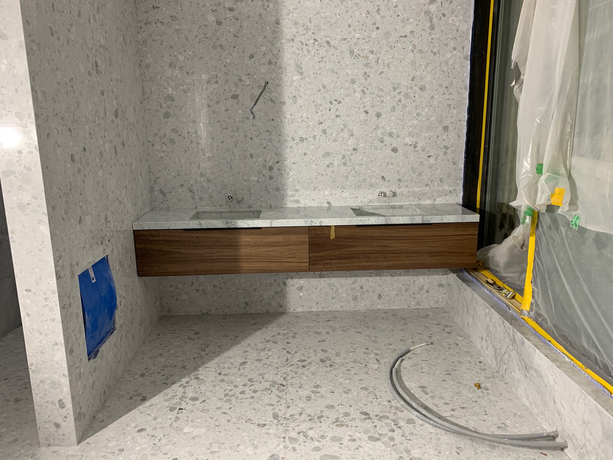 Fyra badrum i natursten och terrazzo